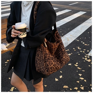 Detail of a large leopard print tote bag in soft suede fabric for autumn street style