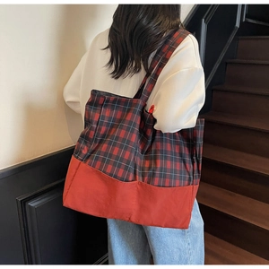 Vue détaillée du grand sac cabas à carreaux rouge et noir avec bandoulière pratique