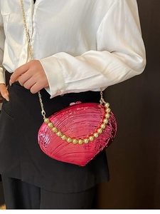 Hot pink shell-shaped acrylic shoulder bag with gold beaded detail and metal chain