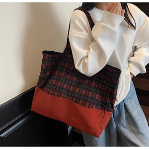 Détail du sac cabas à carreaux rouge et noir avec coutures en toile et bandoulière