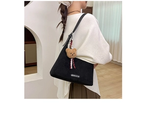 Détail du grand sac cabas noir mat avec pendentif ours en peluche et étiquette blanche
