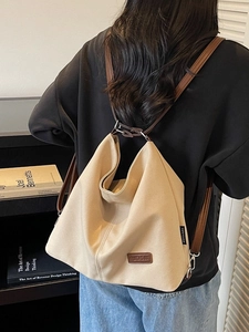 Minimalist beige canvas tote bag with brown leather straps shown from a back perspective