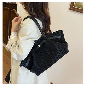 Détail du sac cabas en velours à imprimé léopard noir avec boucle en métal doré chic