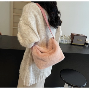 Dettaglio di una borsa a secchiello in peluche rosa con pelliccia sintetica e tracolla