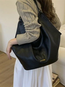 Large black leather tote bag for women showing a stylish shoulder bag on a model
