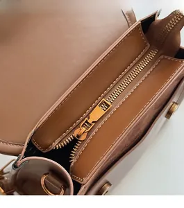 Macro detail of the smooth metal zipper and suede lining inside the brown leather bag