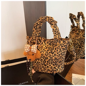 Detail of leopard print bucket bag with plush dog charm and elastic scrunchie handle