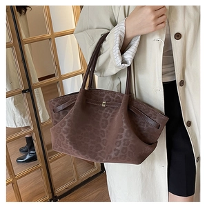Detail of vintage leopard print tote bag with metal buckle and soft suede texture
