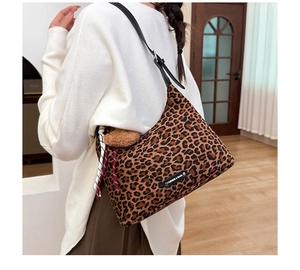 Détail du sac hobo léopard avec bandoulière en cuir et pendentif ours en peluche