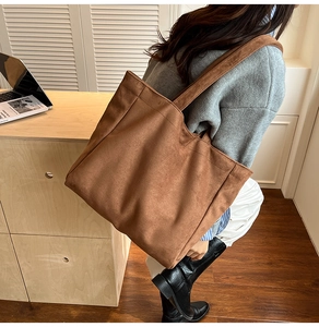 Brown suede tote bag shown on shoulder in a minimalist office setting for daily use