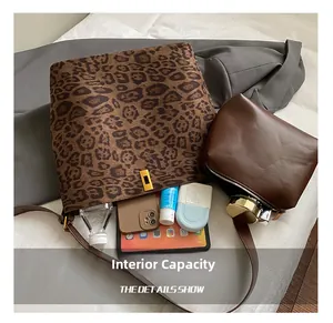 Macro view of leopard print tote bag interior capacity with leather pouch and essentials