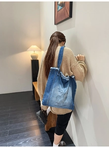 Detail of denim tote bag with tropical beach print and stylish frayed edges on the strap
