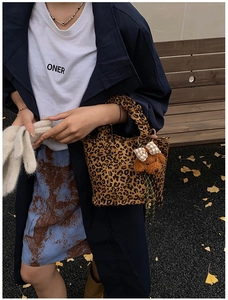 Detail of leopard print tote bag with soft ruffled handle and cute dog plush pendant