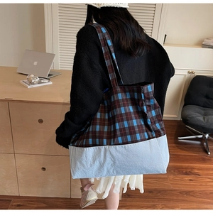 Détail du sac cabas en toile à carreaux montrant sa grande capacité et son design