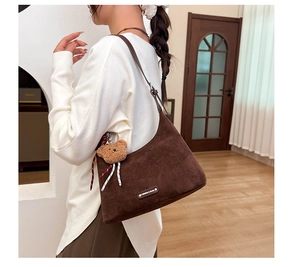 Détail du sac cabas en daim marron foncé avec pendentif ours en peluche et boucle en métal