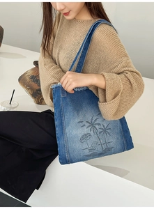 Detailed texture of blue denim tote bag with summer palm tree and umbrella print