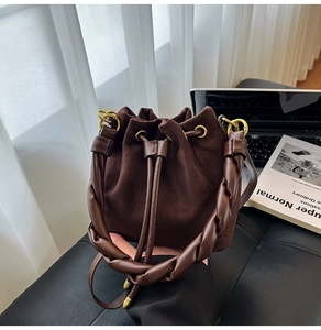Détail du sac seau en daim marron foncé avec anse tressée et fermeture à cordon