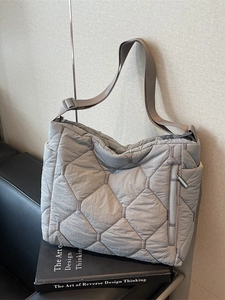 Quilted puffer tote bag in grey with adjustable shoulder strap and side zipper pocket