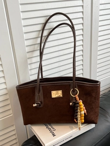 Brown suede tote bag with leopard print accent, golden logo, and beaded tassel charm