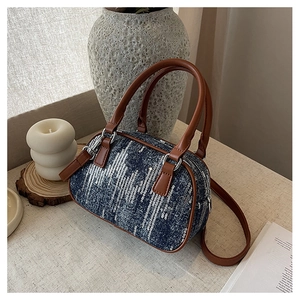 Detail der blauen Denim-Bostontasche mit silbernen Pailletten, braunem Ledergriff und Zipper