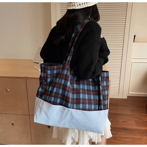 Détail de la couture à carreaux et de la texture en tissu bleu du grand sac cabas