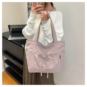 Detail of mauve canvas tote bag with drawstring bow and functional side pockets
