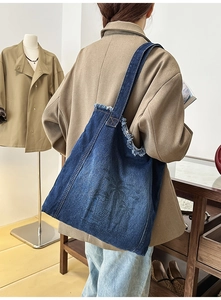 Detailed frayed edges and coconut tree print on denim tote bag with single shoulder strap