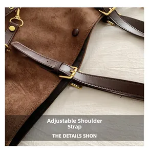 Detail of adjustable leather strap and golden buckle on brown suede tote bag