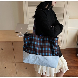 Grand sac cabas à carreaux avec longues anses posé à côté d'un ordinateur