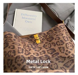 Close-up of golden square twist lock on leopard print tote bag with brown leather strap