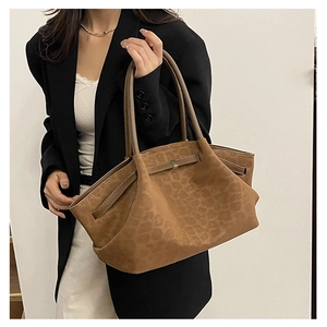 Détail d'un sac cabas léopard vintage avec boucles dorées et lanières en cuir