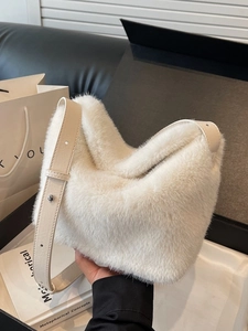 Borsa a secchiello bianca in morbida ecopelliccia con tracolla in pelle beige e sfondo chic
