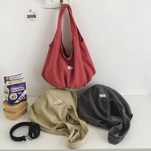 Dettaglio delle borse tote in nylon a scacchi nei colori rosso, beige e grigio