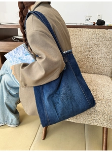 Detail of vintage denim tote bag with palm tree print and stylish frayed edge design