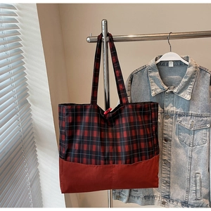 Détail du grand sac cabas en toile à carreaux rouges et noirs avec des doubles poignées