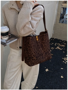 Close-up of leopard print tote bag featuring a golden square buckle and leather strap