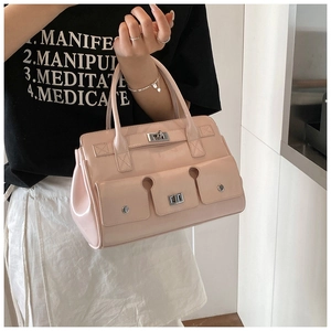 Vue détaillée du sac à main rose brillant avec trois poches avant et fermoirs argentés