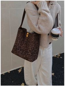 Detail of leopard print bucket bag with gold twist lock on a casual autumn outfit