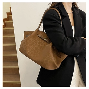 Detail of vintage brown suede leopard print tote bag with dark leather handles and straps