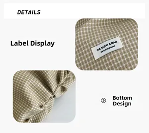 Dettaglio dell'etichetta del marchio e del fondo pieghettato della borsa tote in nylon a scacchi