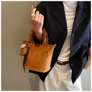 Brown suede mini tote bag featuring gathered handle and plush bear charm accessory