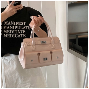 Vue détaillée du sac à main en cuir verni rose pâle avec fermoir tournant et poches à boucles