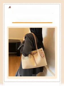 Detail of suede tote bag with brown leather straps and cute plush bear charm