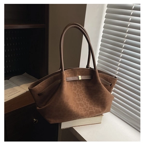Detailed macro view of the leopard print suede fabric and gold buckle on the tote bag