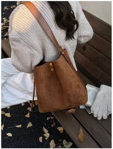 Close-up of brown leopard print tote bag with gold lock buckle and suede texture