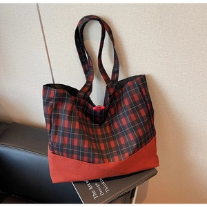 Détail du sac cabas à carreaux rouges avec tissu en toile et fermeture à bascule rouge