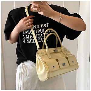 Détail du sac à main jaune à poches multiples avec fermoir métallique et clous décoratifs