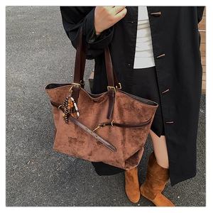 Detail of vintage brown suede tote bag with leather handles and retro bead charms