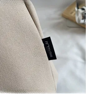 Detail of premium beige canvas fabric with a minimalist branded black woven label