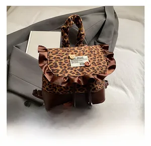 Detail of leopard print backpack with brown ruffles and cute cartoon bear patch